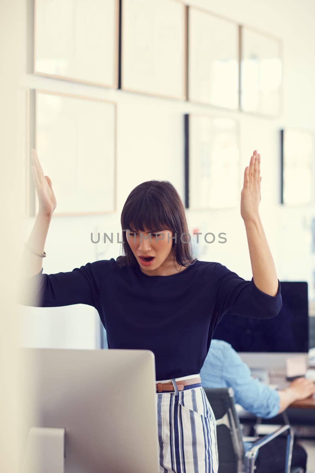 When technology attacks. a young businesswoman using a computer and looking stressed out at her desk in a modern office