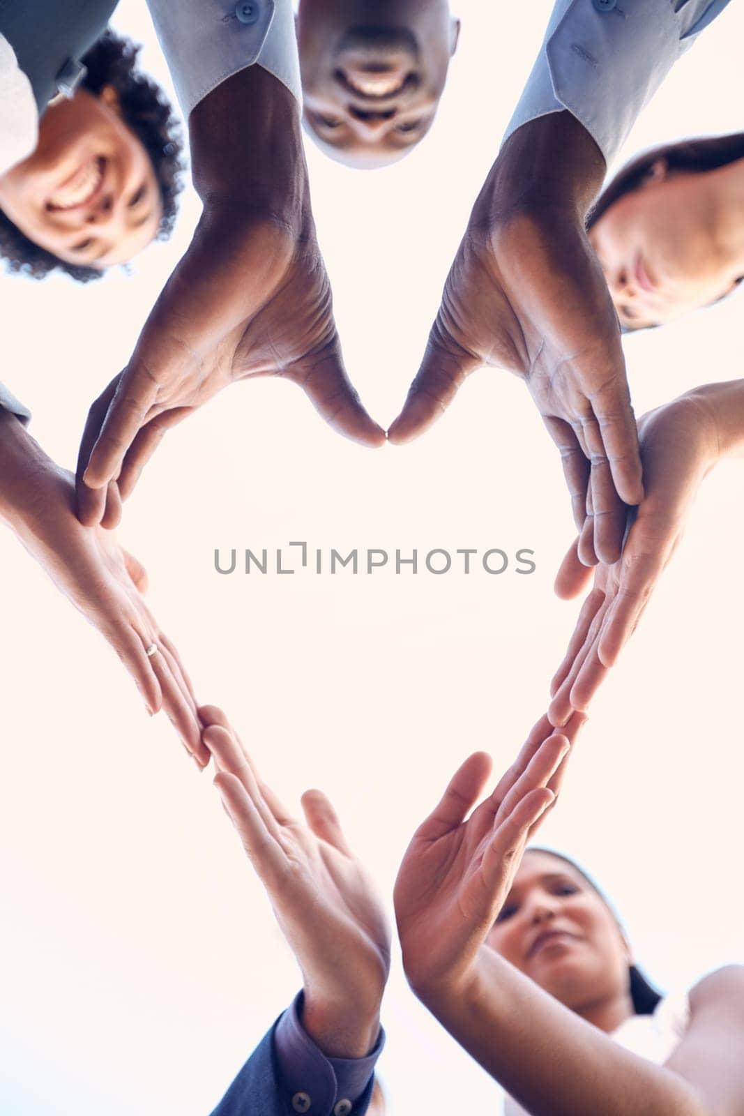 Teamwork lies at the heart of our collective success. Closeup shot of a group of unrecognizable businesspeople making a heart shape with their hands outdoors. by YuriArcurs
