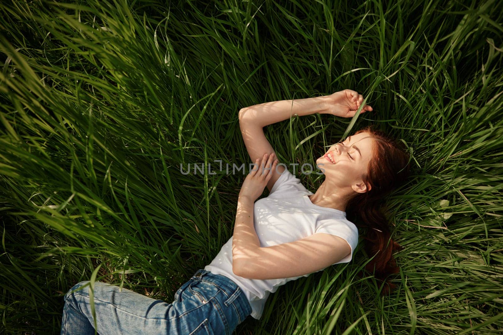 woman resting from worries lying in tall grass by Vichizh