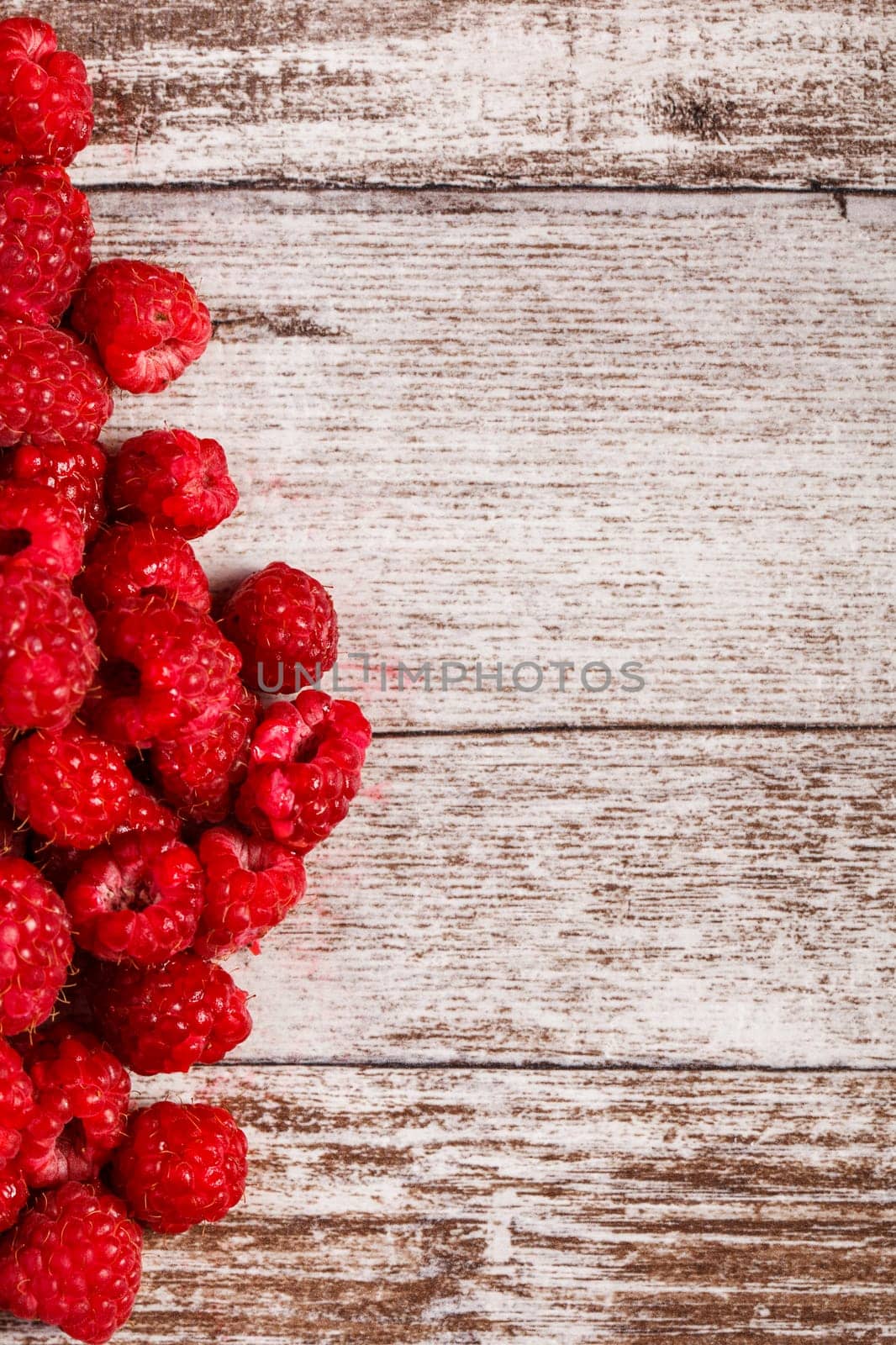 Fresh juicy raspberry on wooden background by DCStudio
