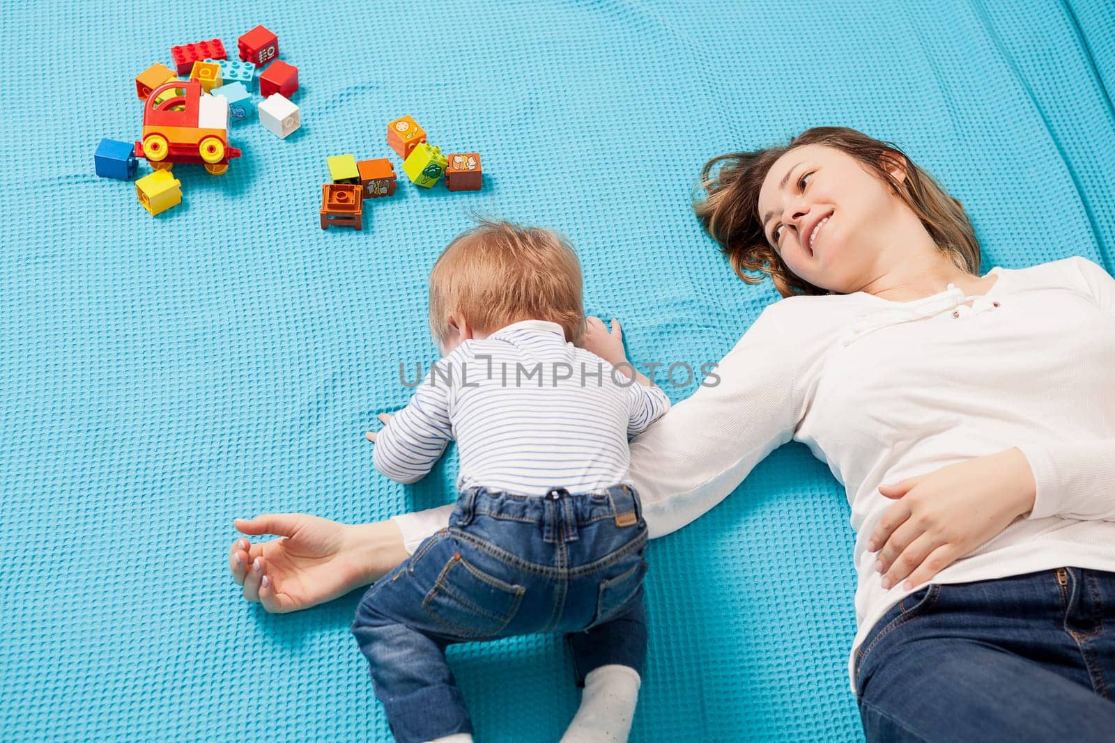 Mother playing with her son in the house by DCStudio