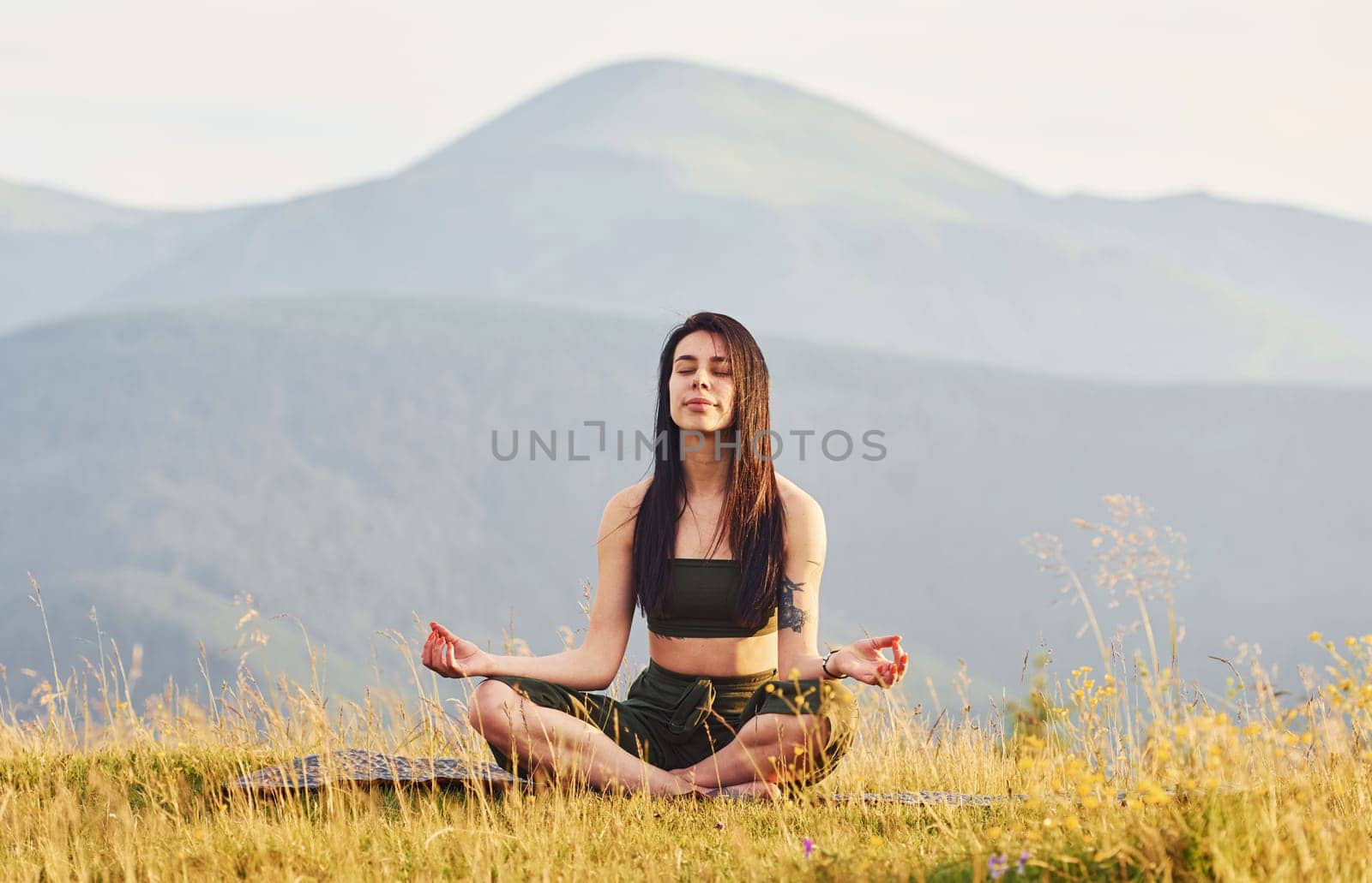 Beautiful young woman doing yoga exercises. Majestic Carpathian Mountains. Beautiful landscape of untouched nature.