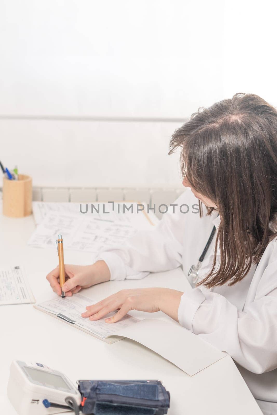 woman doctor writing a prescription to her patient by joseantona