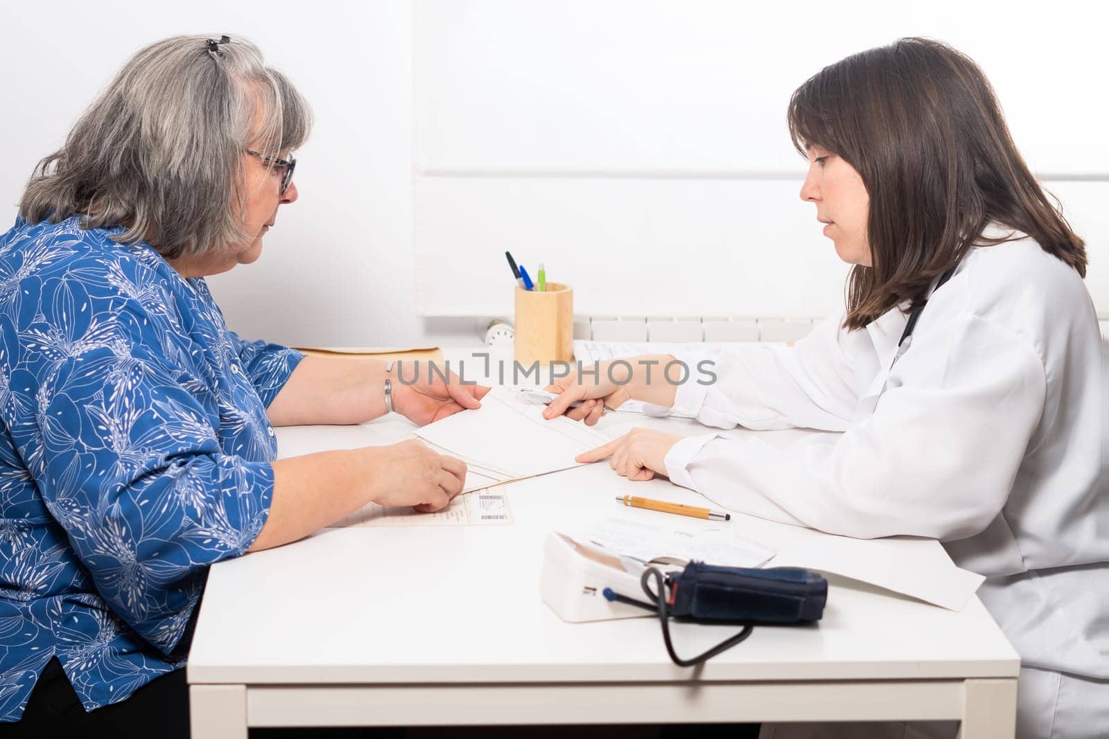 young female doctor explaining her blood test results to her patient by joseantona
