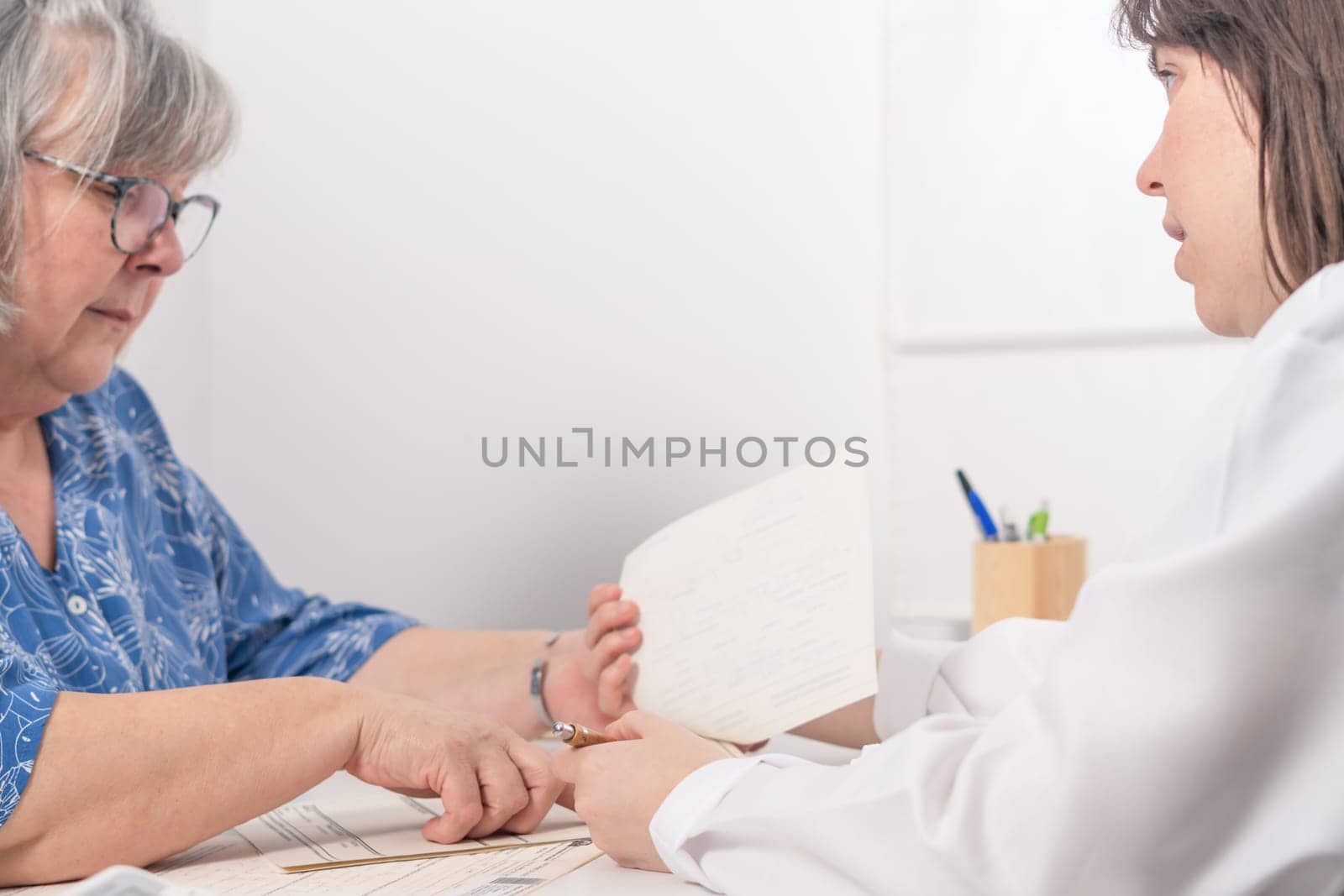 young female doctor explaining to her elderly patient the results of her blood test at the doctor's office