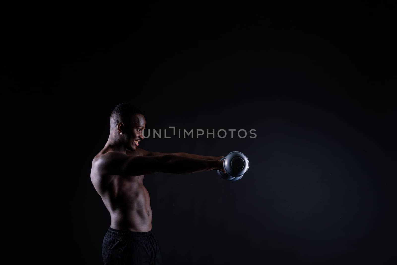 One young african muscular build man standing topless silhouette isolated on black background by Zelenin