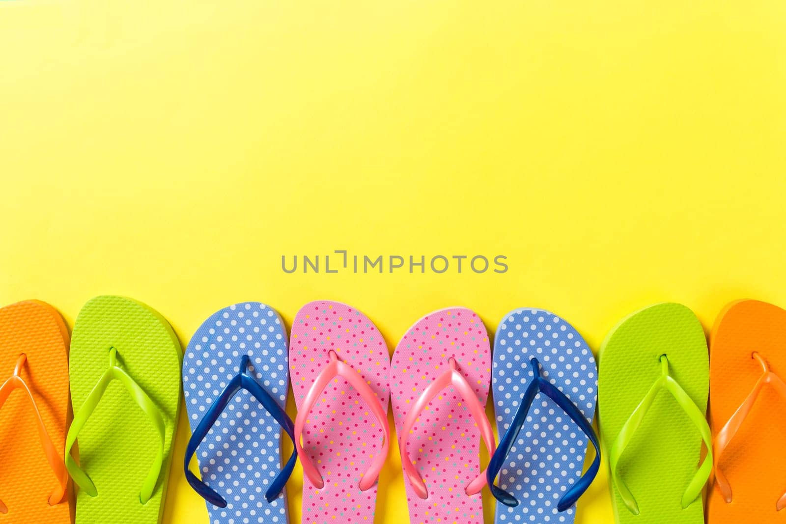 a lot of flip flop colored sandals, summer vacation on colored background, copy space top view.