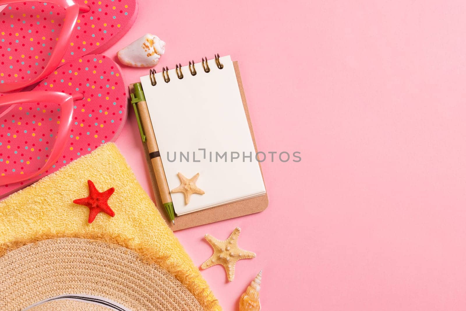 Flat lay, top view Travel concept. summer accessories with note paper and seashell on pink background.