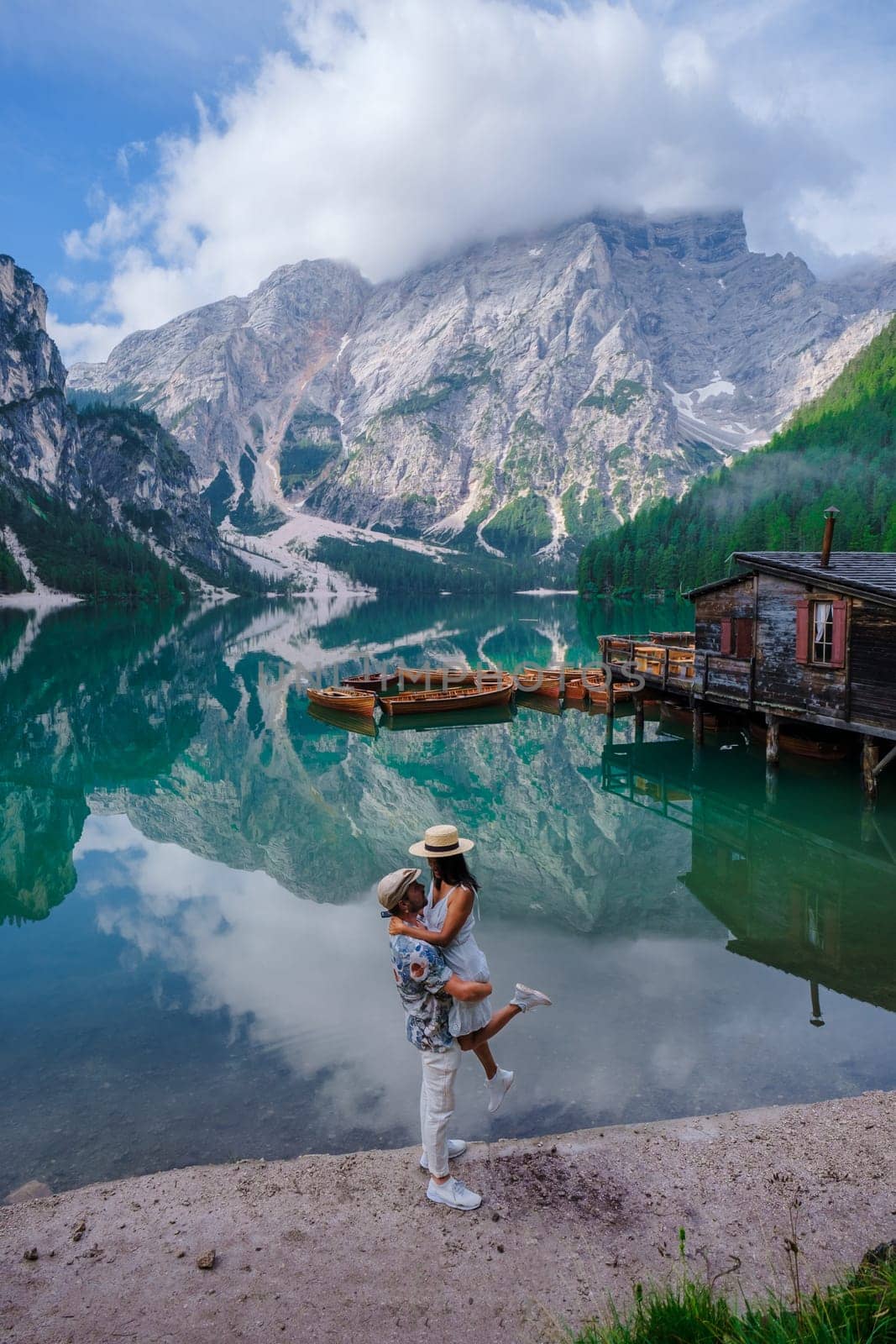 Couple men and women at Lago Di Braies lake mountains Italy, Pragser Wildsee South Tyrol Dolomites by fokkebok