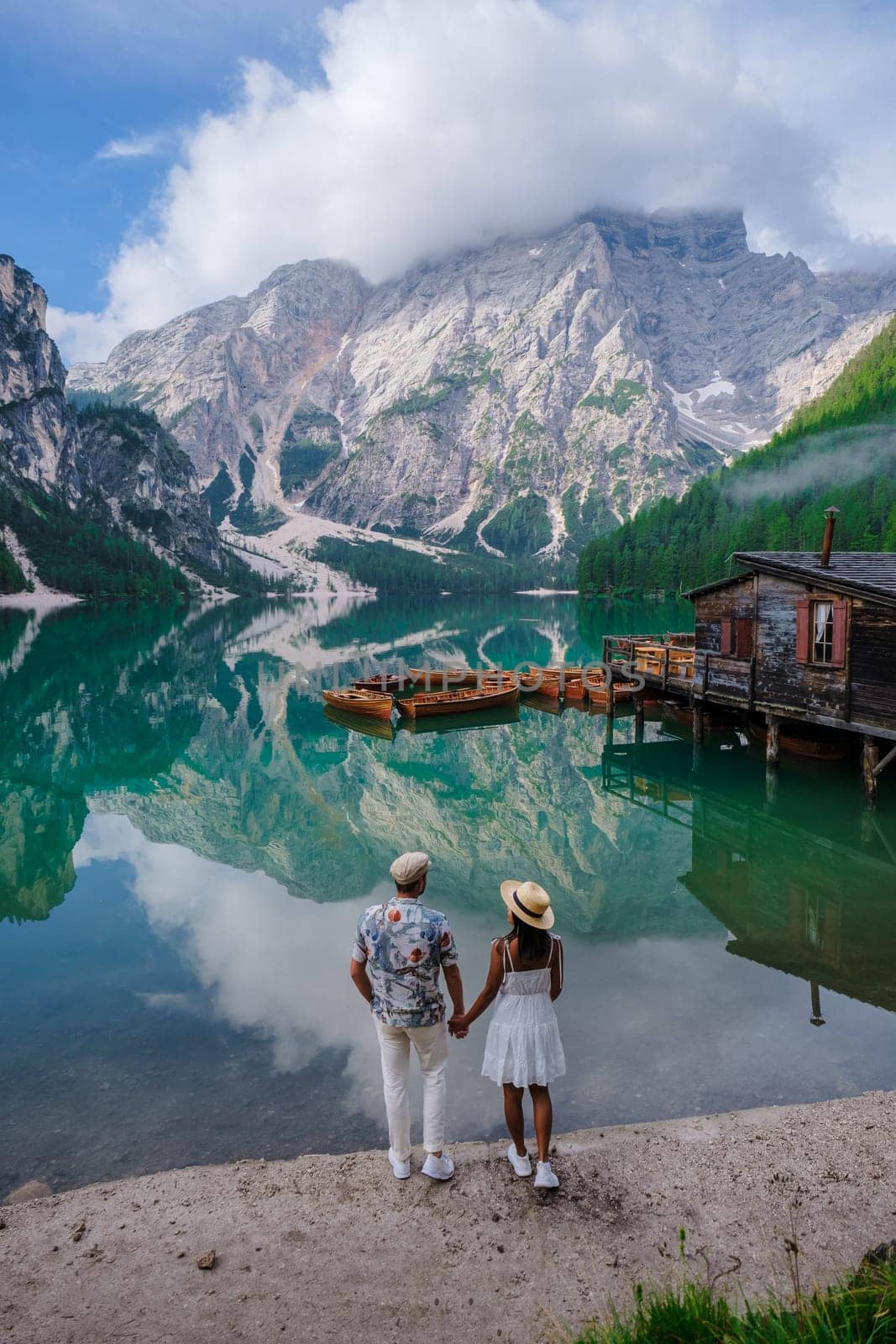 Couple of men and women at Lago Di Braies Italy, Pragser Wildsee in South Tyrol, Beautiful lake in the Italian alps, Lago di Braies.