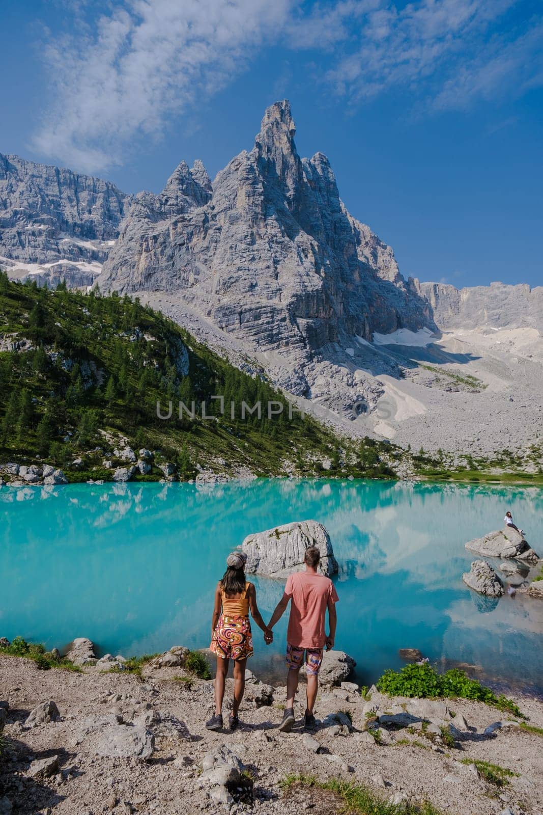 Couple of men and women visiting Lago di Sorapis in the Italian Dolomites,blue lake Lago di Sorapis, Lake Sorapis Dolomites, Italy. by fokkebok
