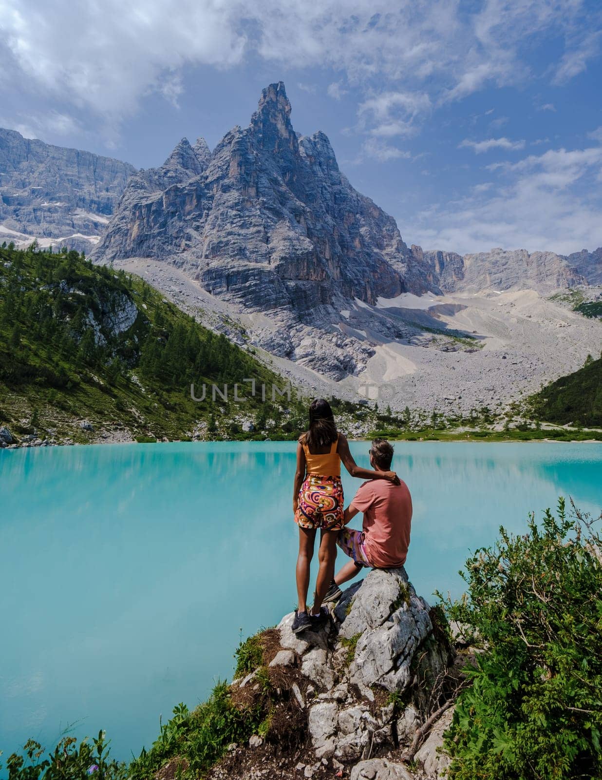 Couple of men and women visiting Lago di Sorapis in the Italian Dolomites,blue lake Lago di Sorapis, Lake Sorapis Dolomites, Italy. by fokkebok