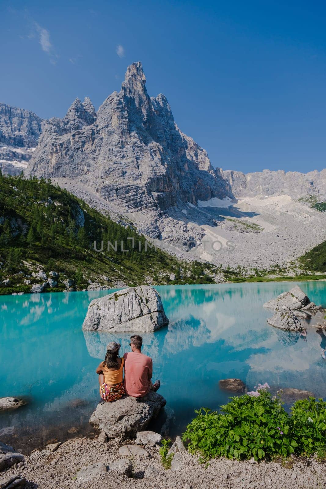 Couple of men and women visiting Lago di Sorapis in the Italian Dolomites,blue lake Lago di Sorapis, Lake Sorapis Dolomites, Italy. by fokkebok