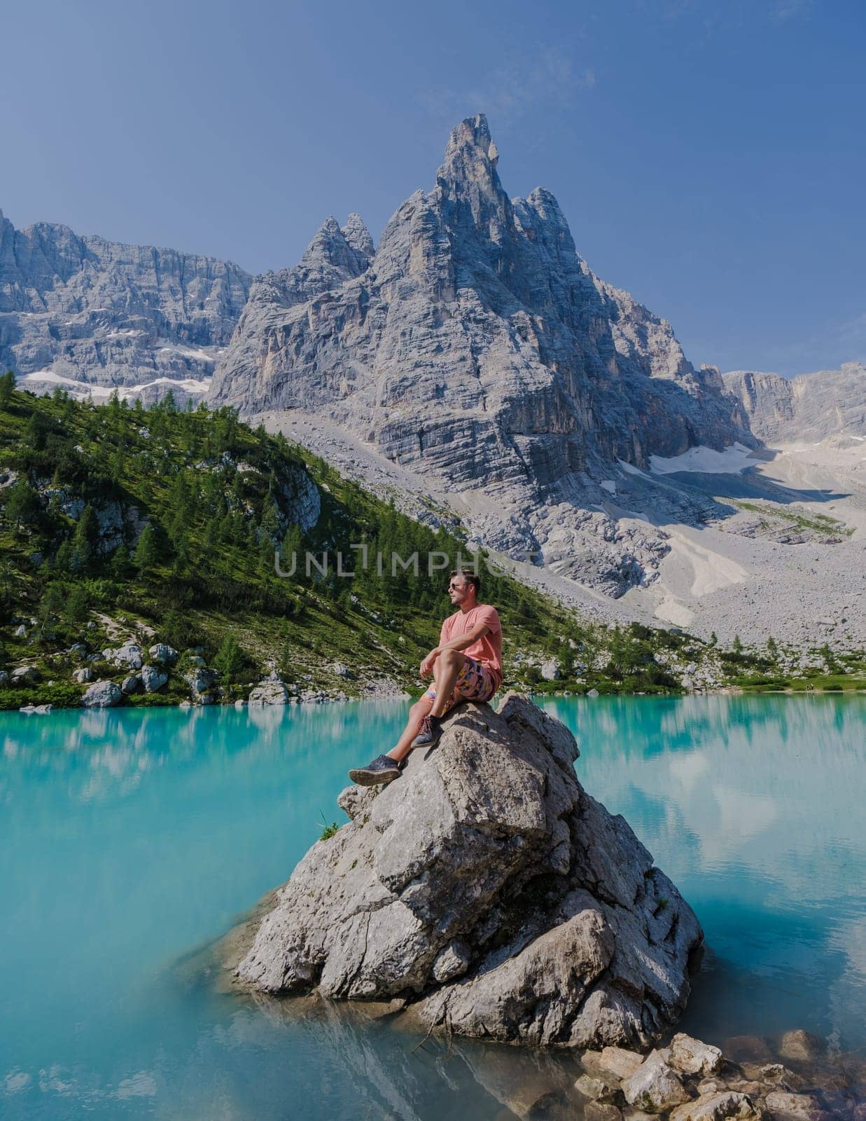 men visiting Lago di Sorapis in the Italian Dolomites,blue lake, Lake Sorapis Dolomites, Italy. by fokkebok