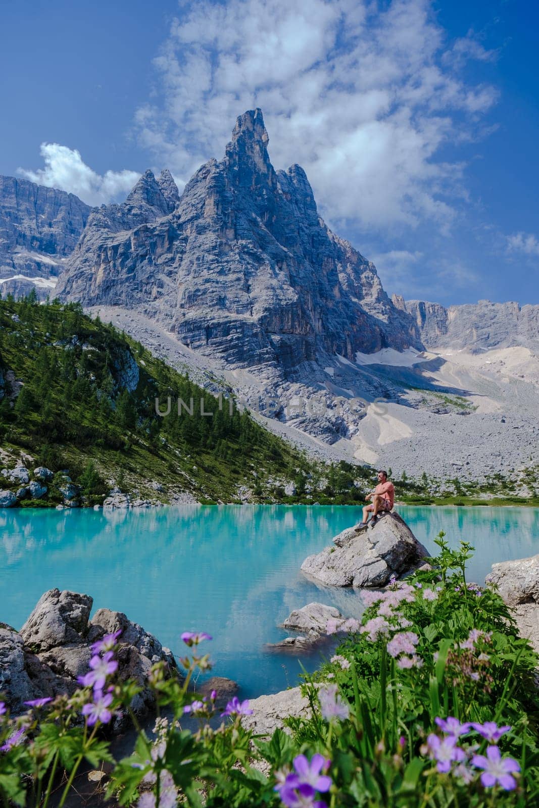 men visiting Lago di Sorapis in the Italian Dolomites,blue lake, Lake Sorapis Dolomites, Italy. by fokkebok