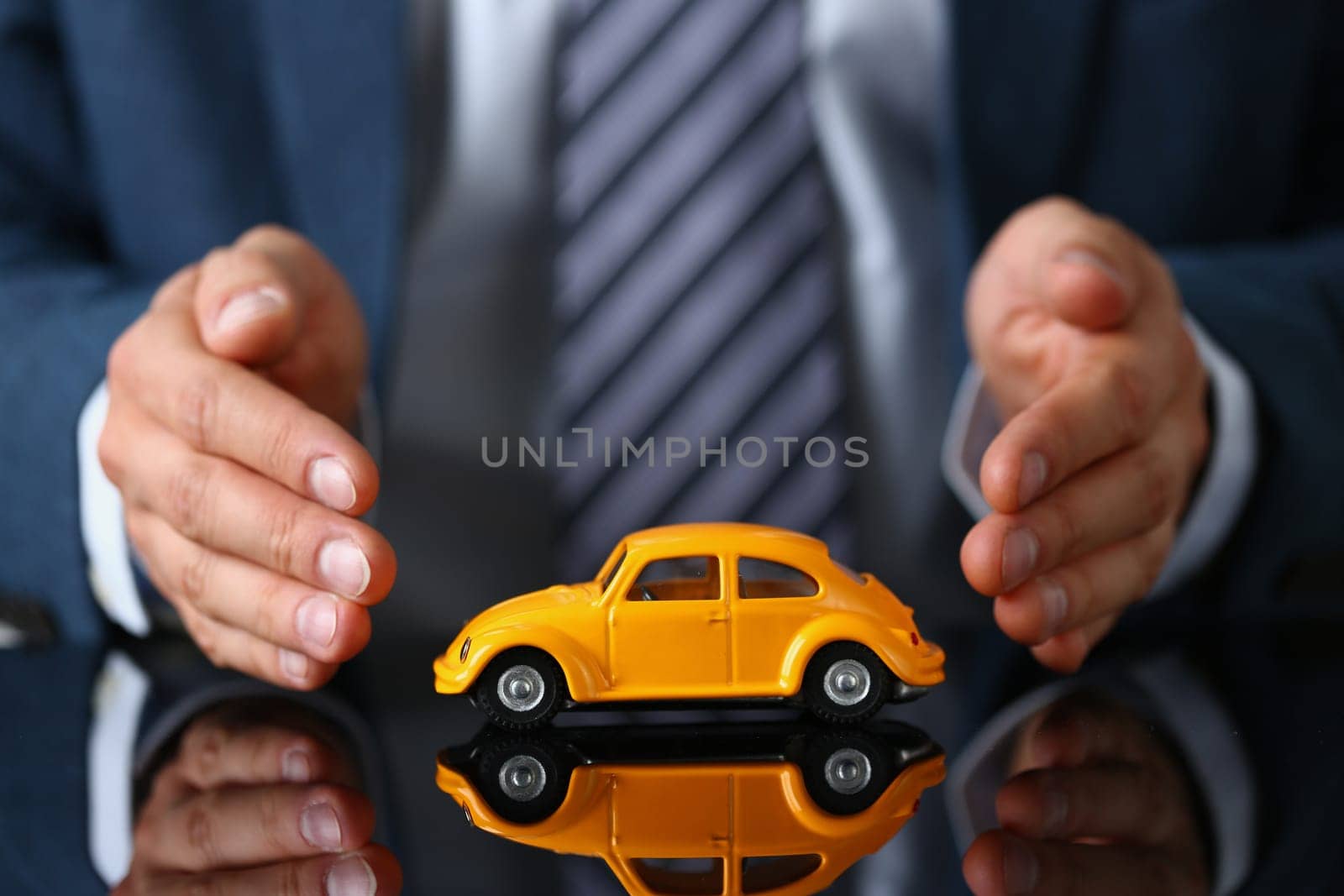 Male hands of insurance agent and car protection closeup by kuprevich