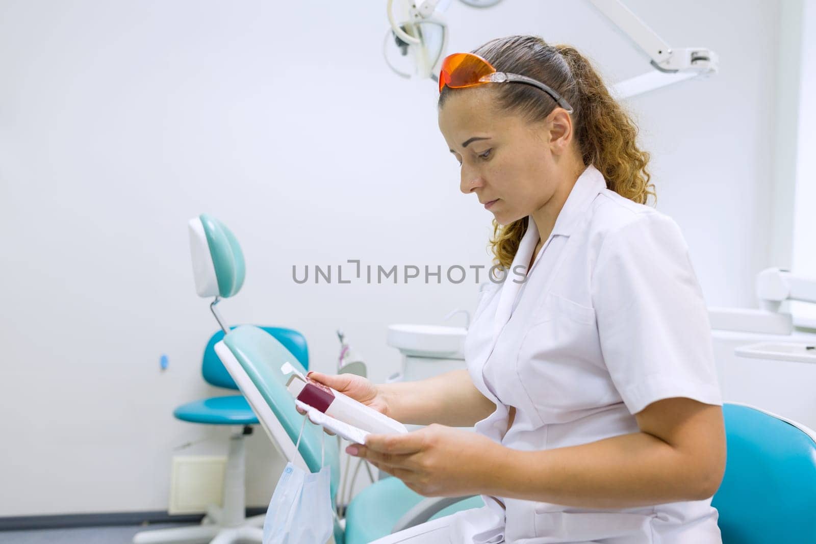 Serious female dentist doctor reading annotation of medicine by VH-studio