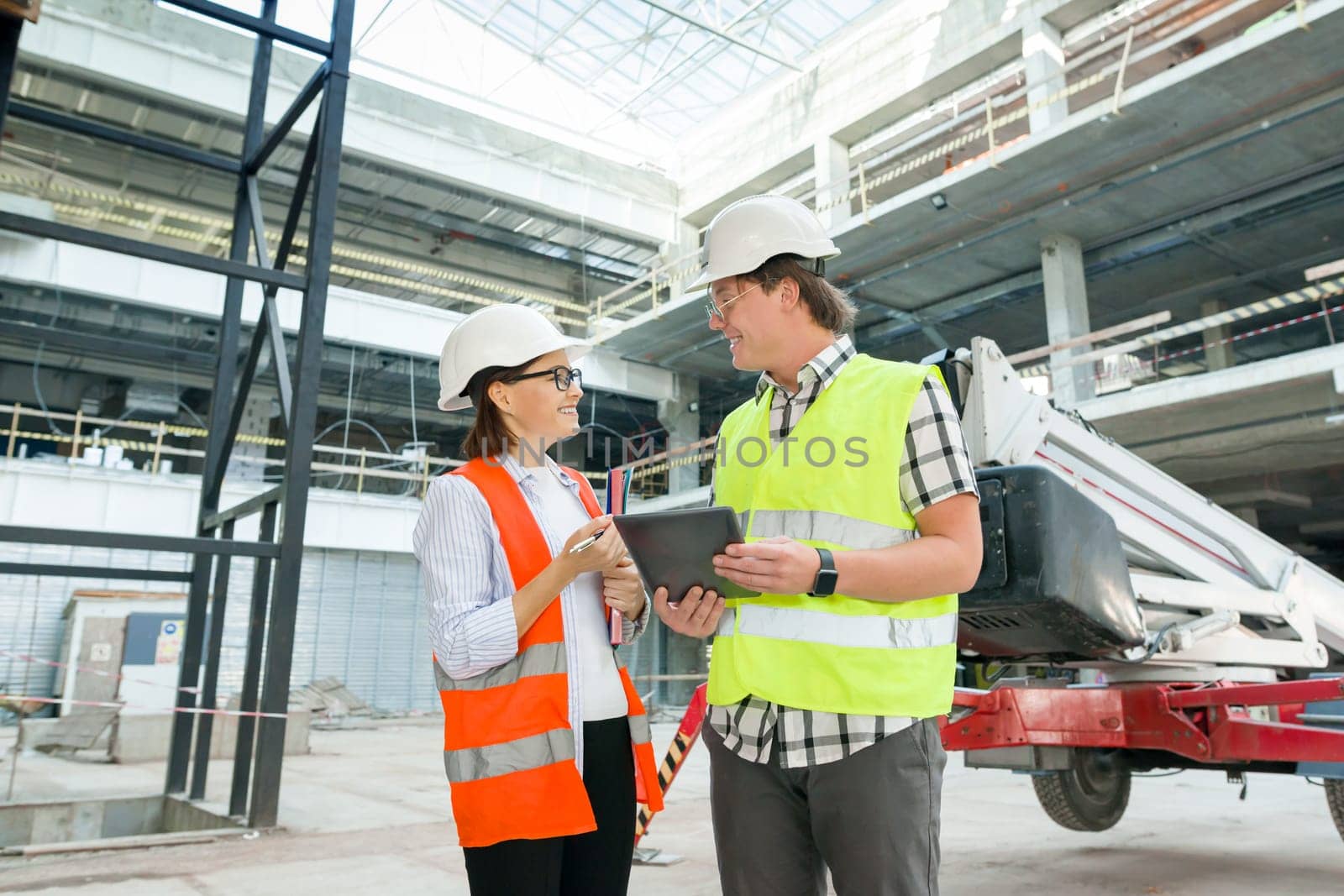 Industrial portrait of male and female engineers in construction of commercial administrative building