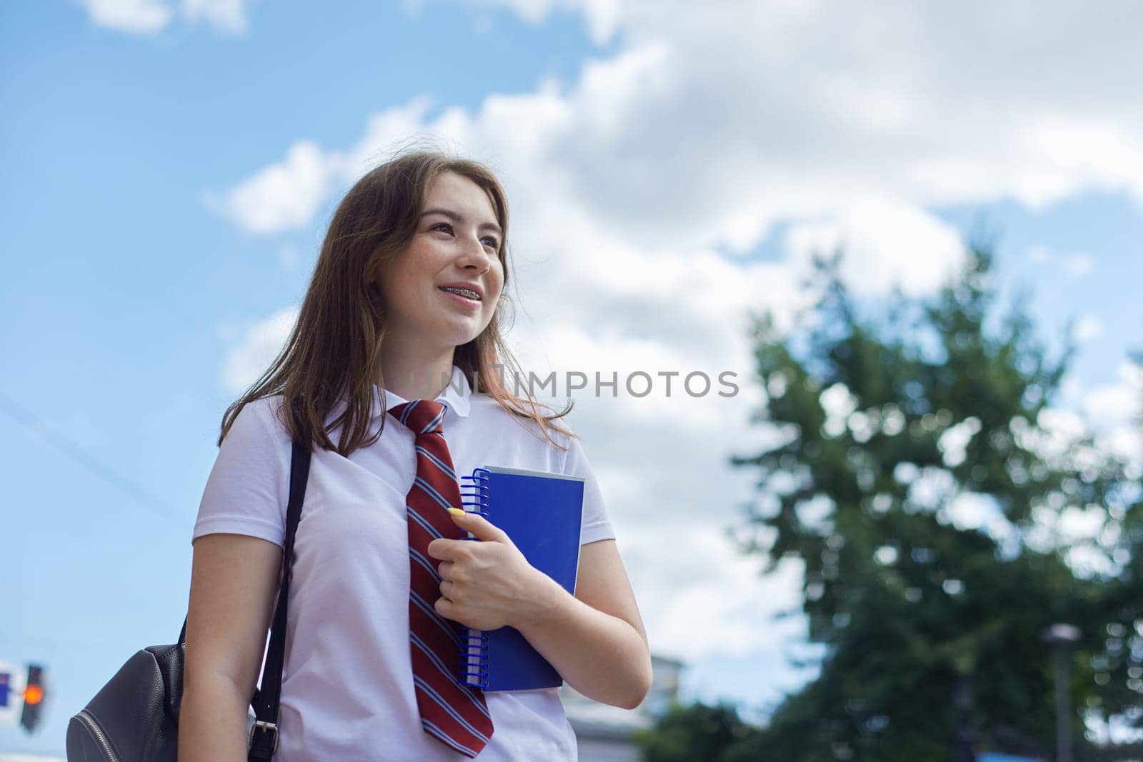 Portrait of smiling girl student of 17, 18 years old with braces on her teeth, copy space