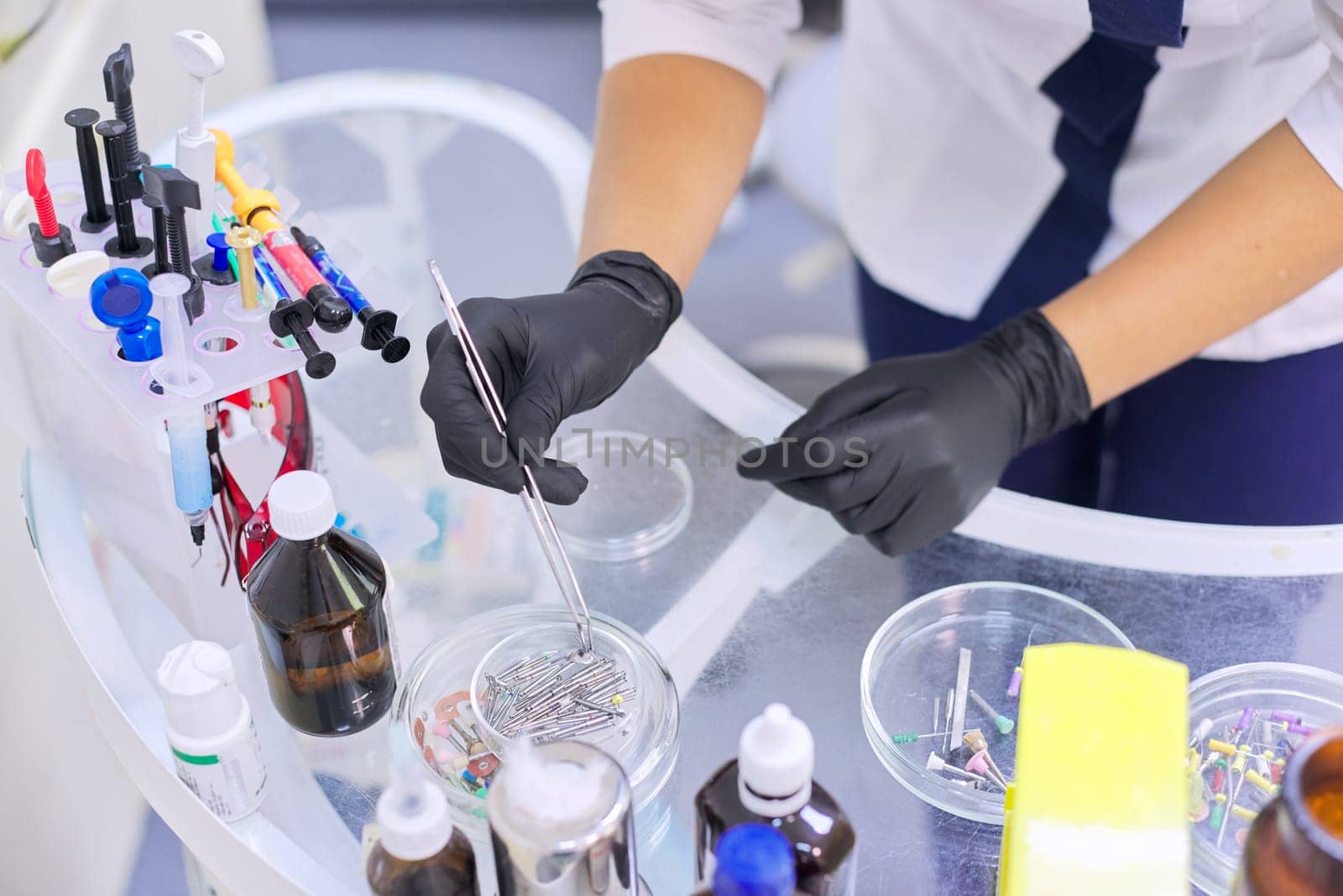 Female dentist doctor working with medical materials and special professional tools on work table. Technology, medicine, care and dental health.