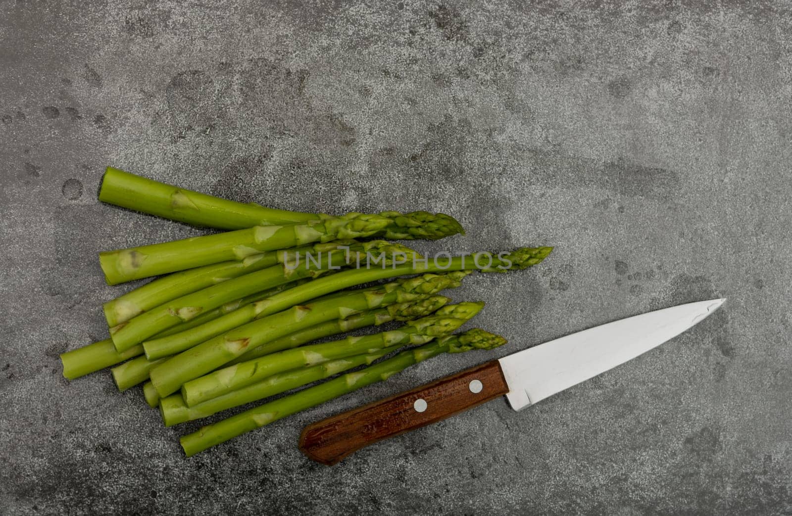 Fresh green asparagus on stone table surface by BreakingTheWalls