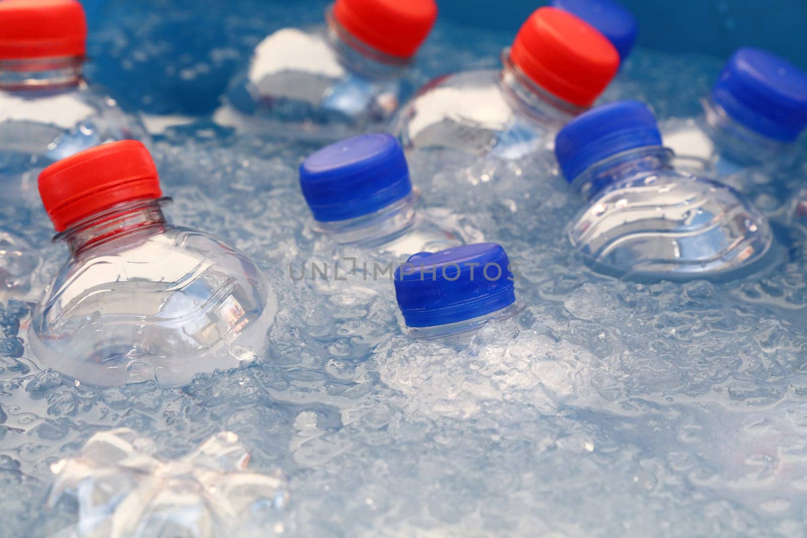 PET plastic bottles of cold drinking water in ice by BreakingTheWalls