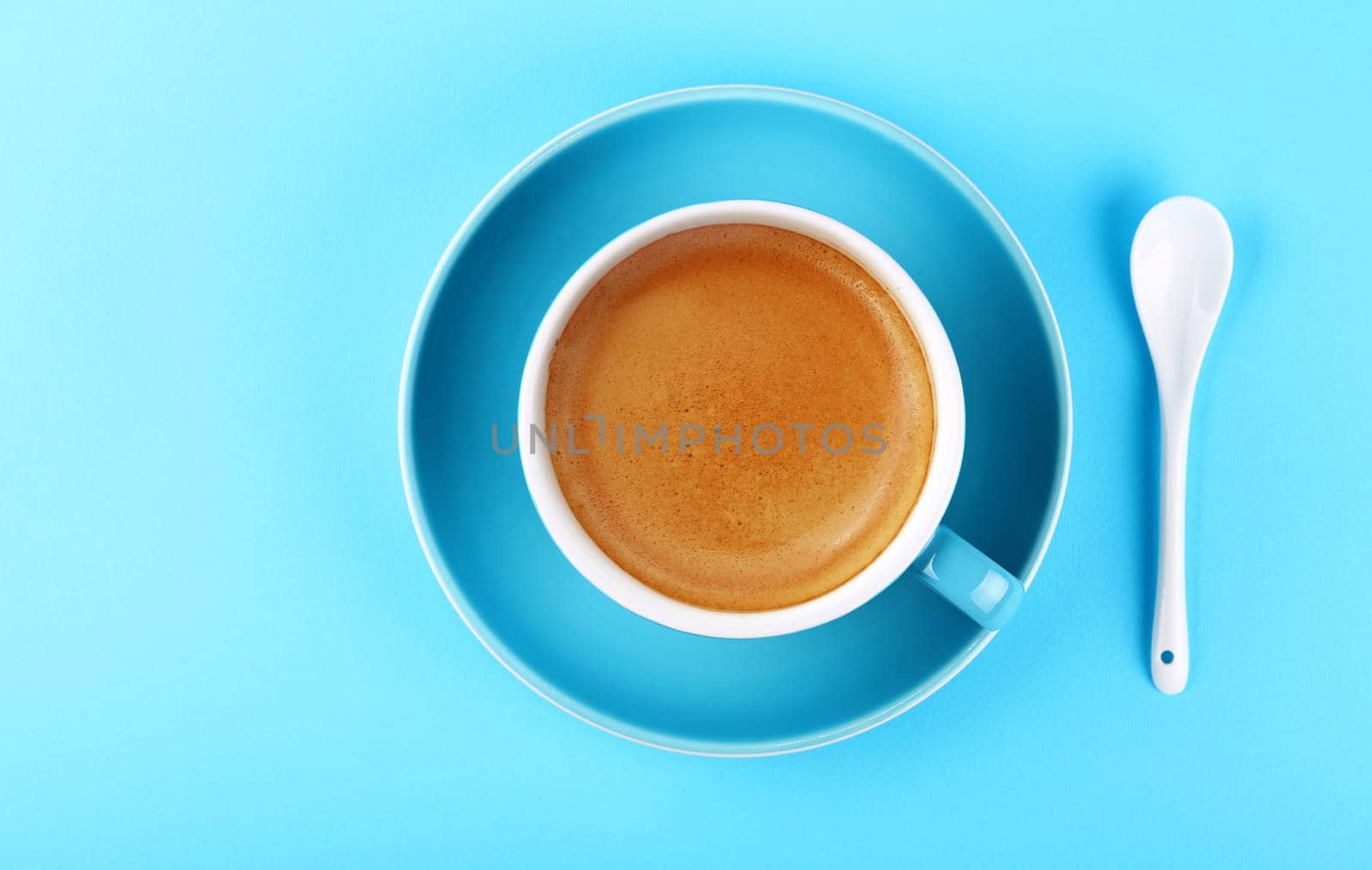 Full cup of espresso coffee on blue paper by BreakingTheWalls