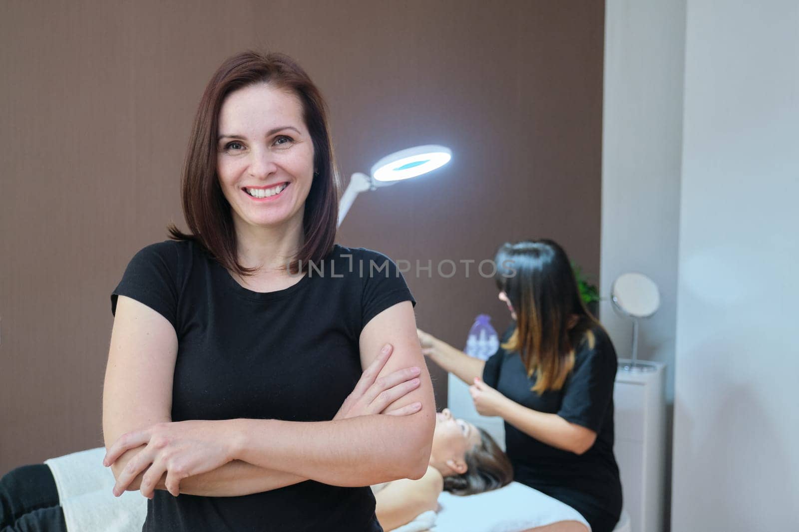 Portrait of confident female specialist in spa beauty salon, female cosmetologist looking at camera with crossed arms