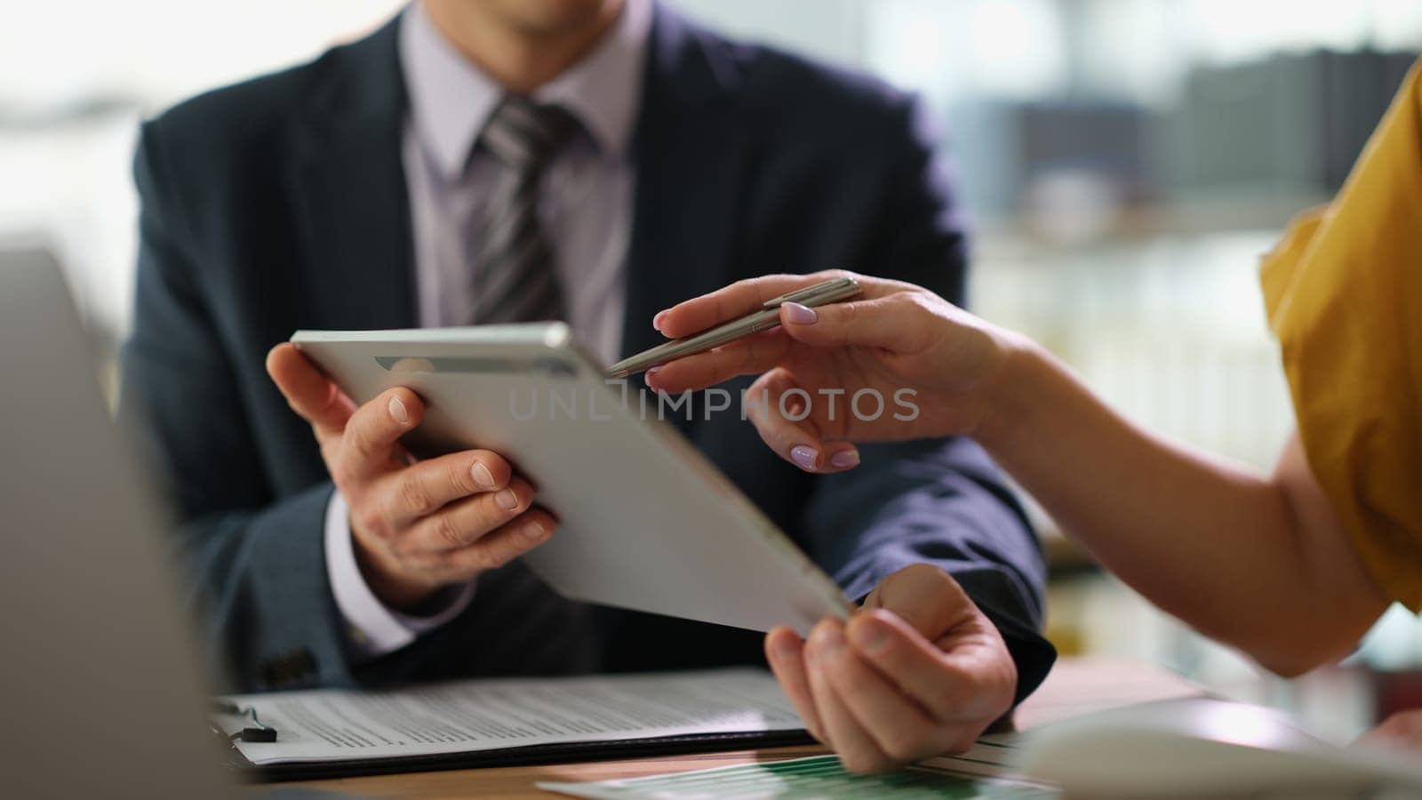 Business partners discussing information on tablet and showing screen with pen closeup. Business strategy marketing concept