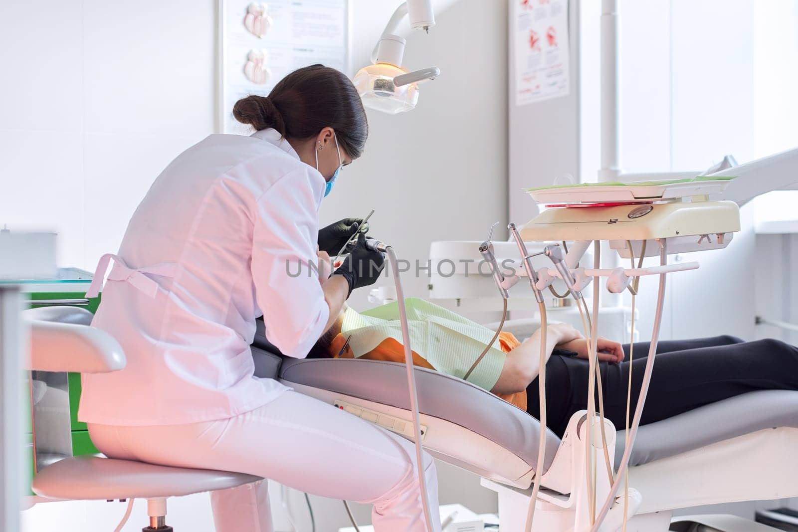 Dental treatment at the dental clinic, female doctor treating patient.