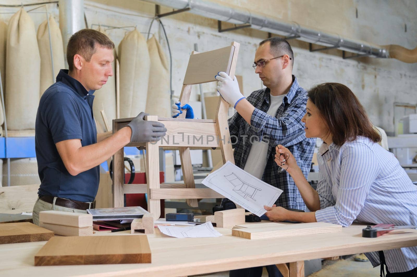 Group of working designers in carpentry workshop by VH-studio