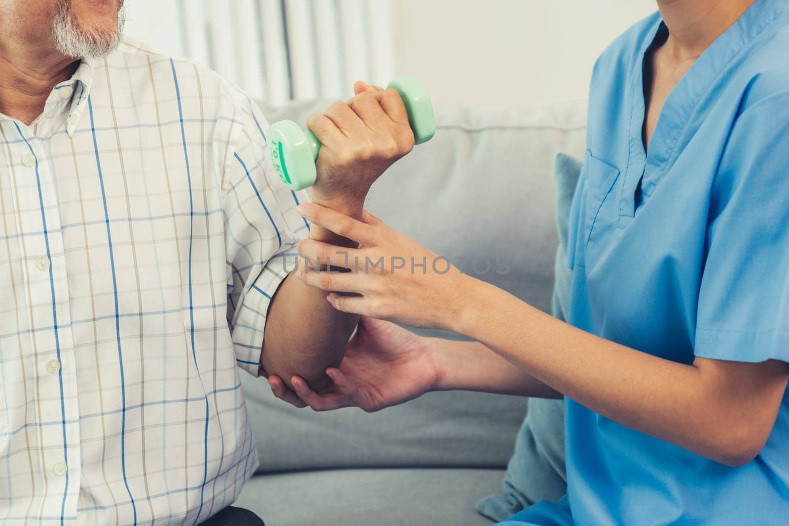 Contented senior patient doing physical therapy with the help of his caregiver. Senior physical therapy, physiotherapy treatment, nursing home for the elderly