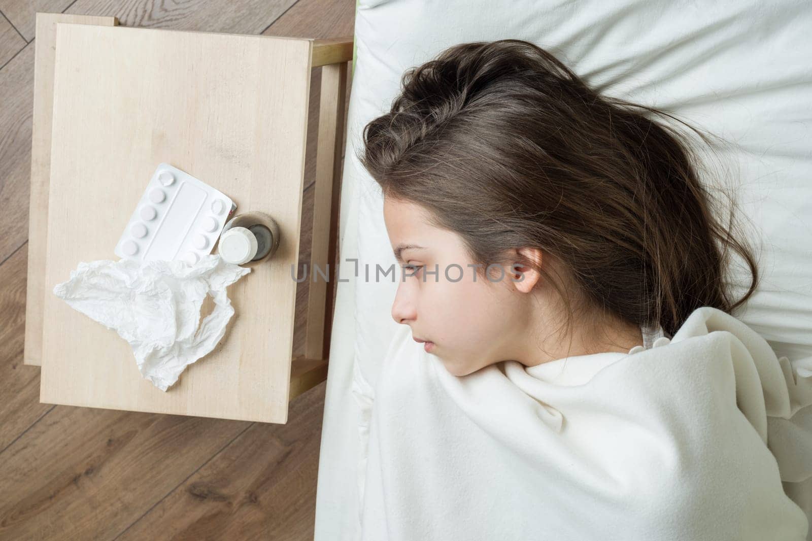 Child in bed at home caught cold, taking medicines, flu season.