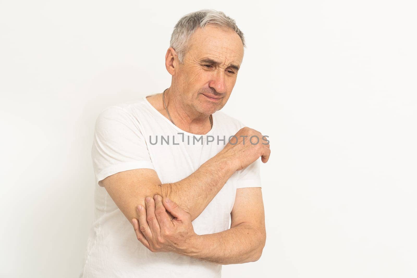 an elderly man hurts his elbow.