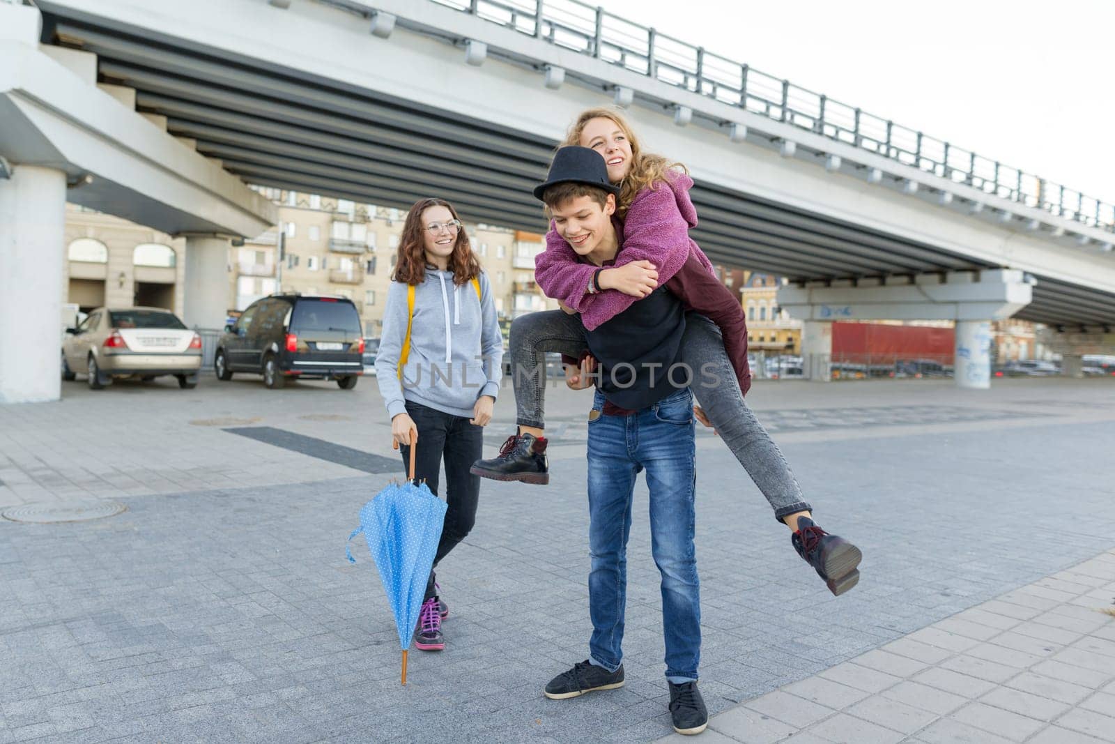 Group of teenagers friends having fun in the city, laughing kids with umbrella by VH-studio