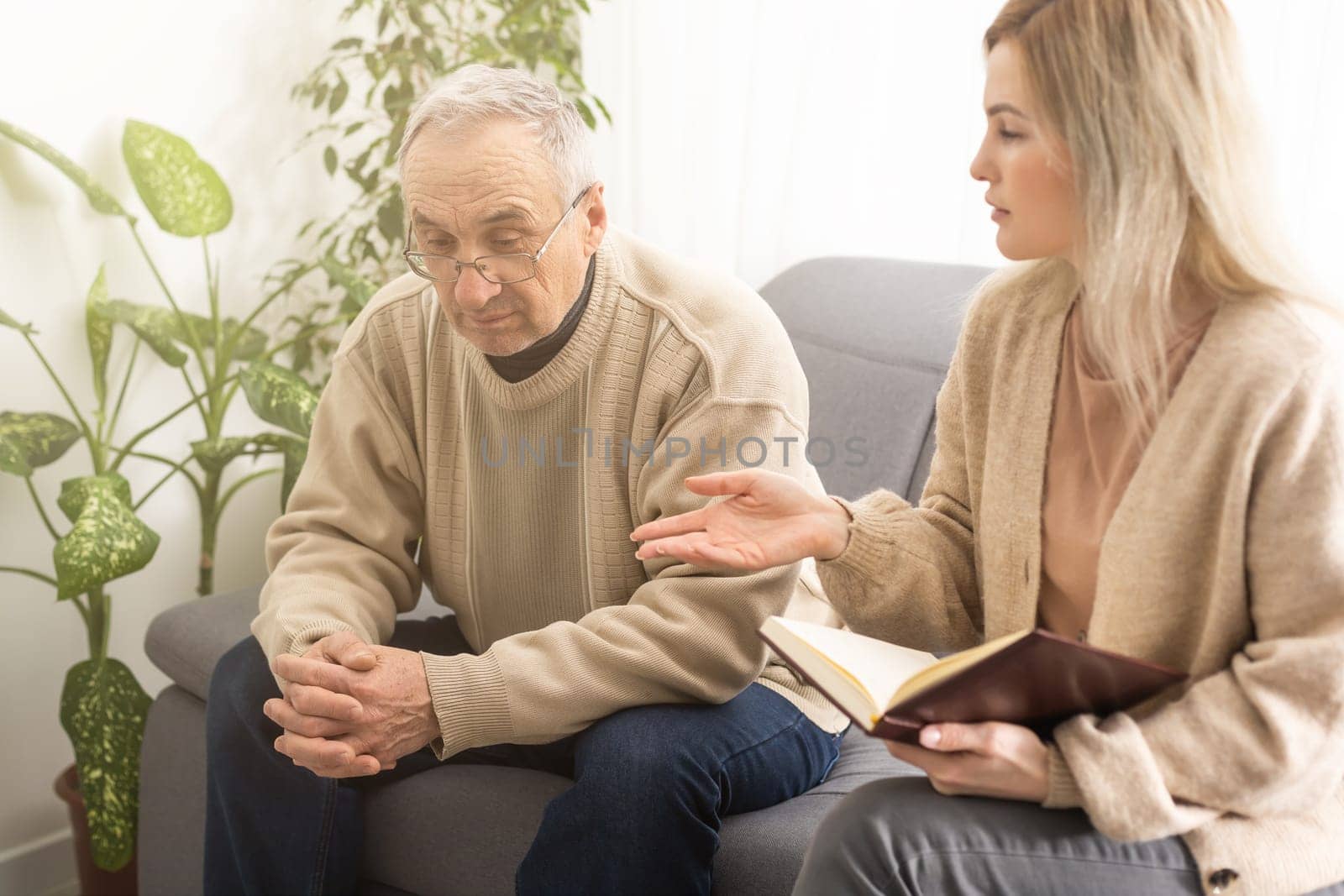 Close up anxious serious old man listening to female doctor at meeting in hospital, therapist physician consulting mature patient about disease, treatment, elderly generation healthcare concept.