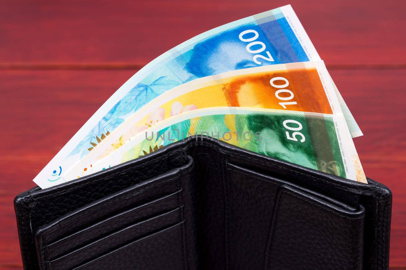 Banknotes from Israel in a black wallet