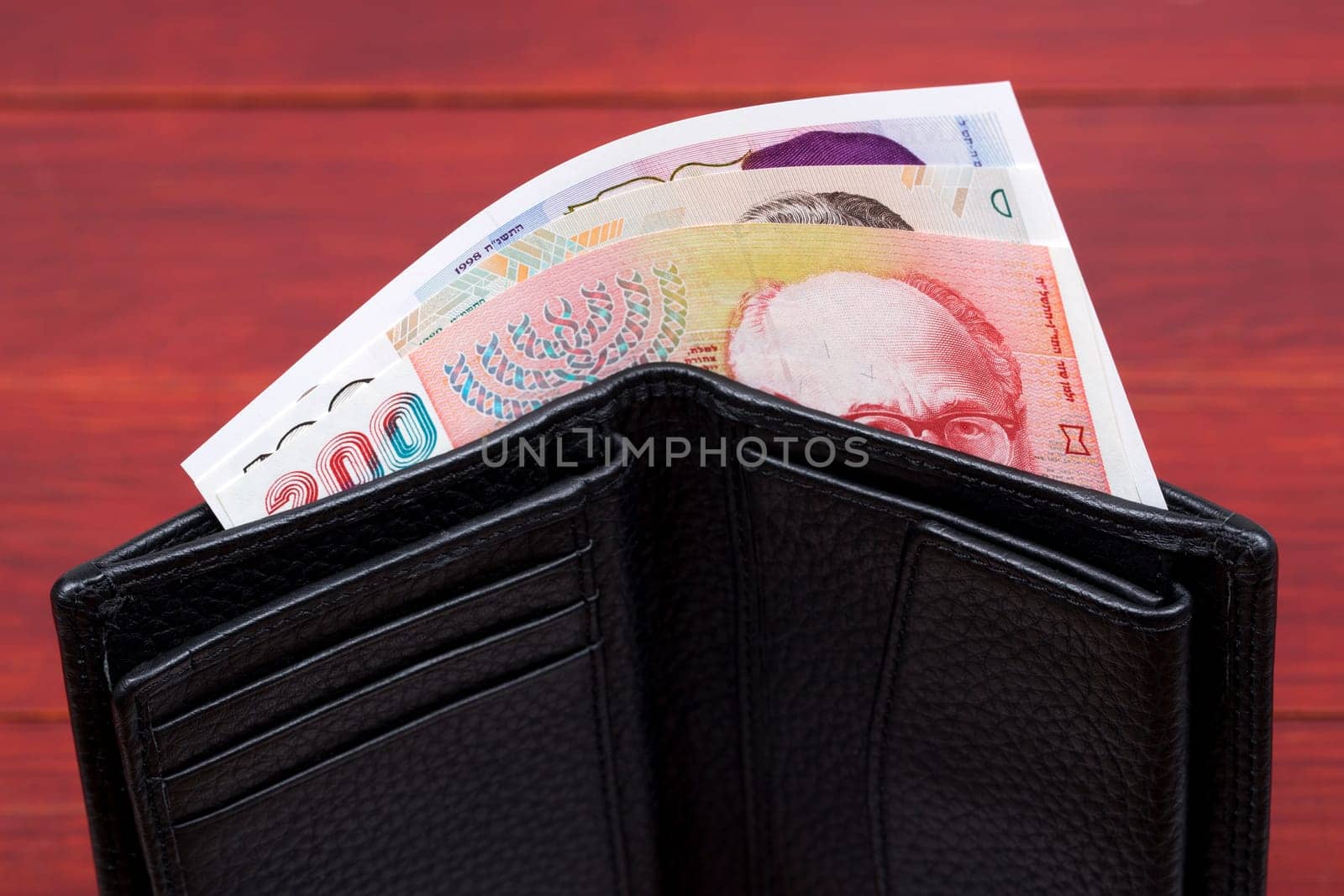 Old banknotes from Israel in a black wallet