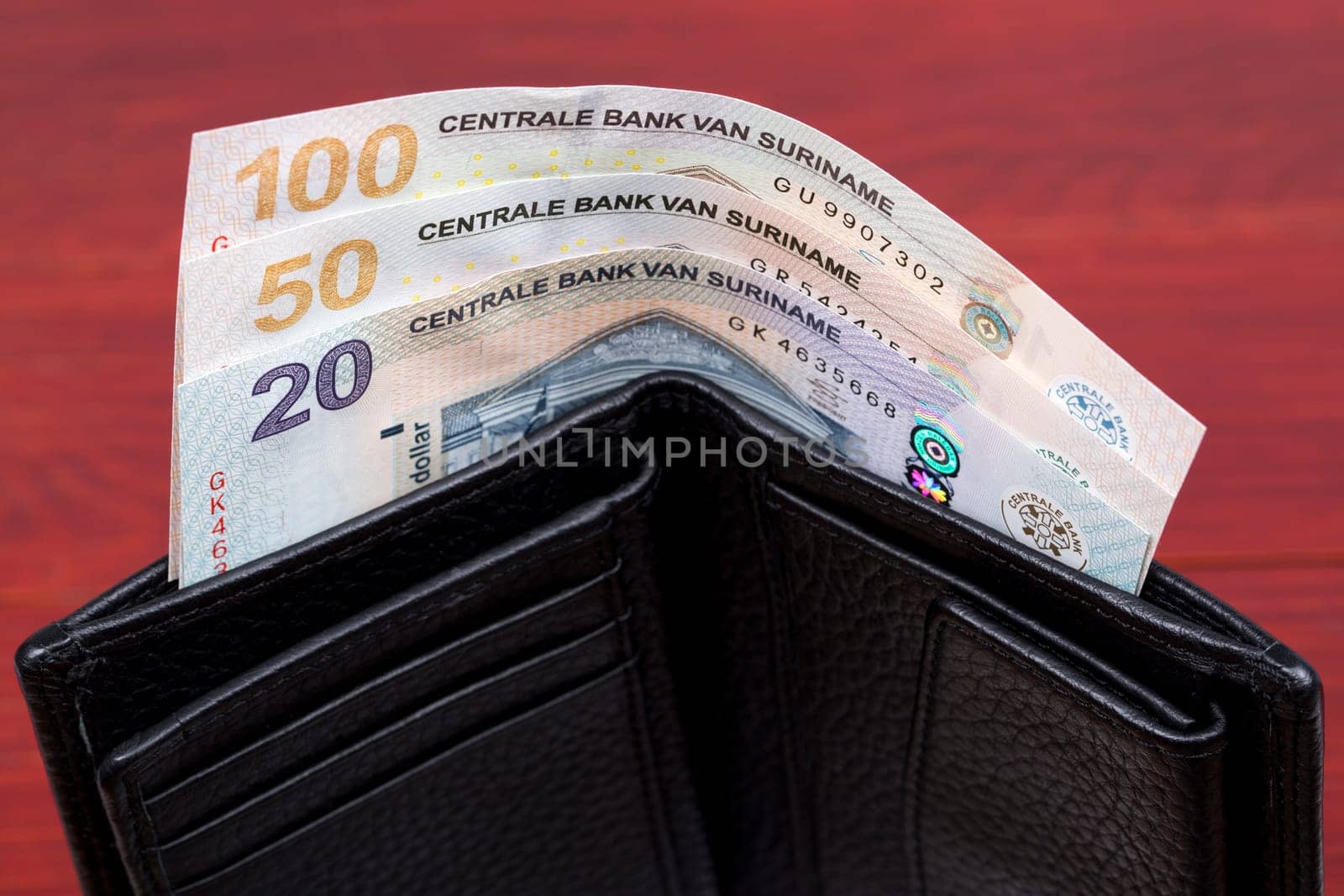 Surinamese dollar in the black wallet