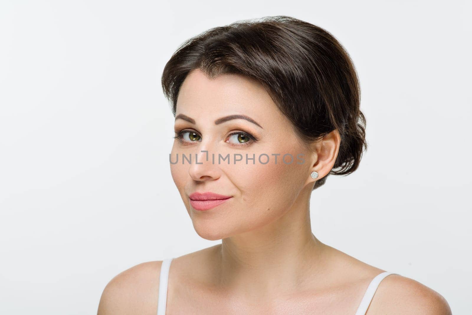 Head shot, beauty portrait of middle aged woman on white isolated background. Smiling female with hairstyle makeup looking at camera. Mature age, 40s, health, skin care, cosmetics concept