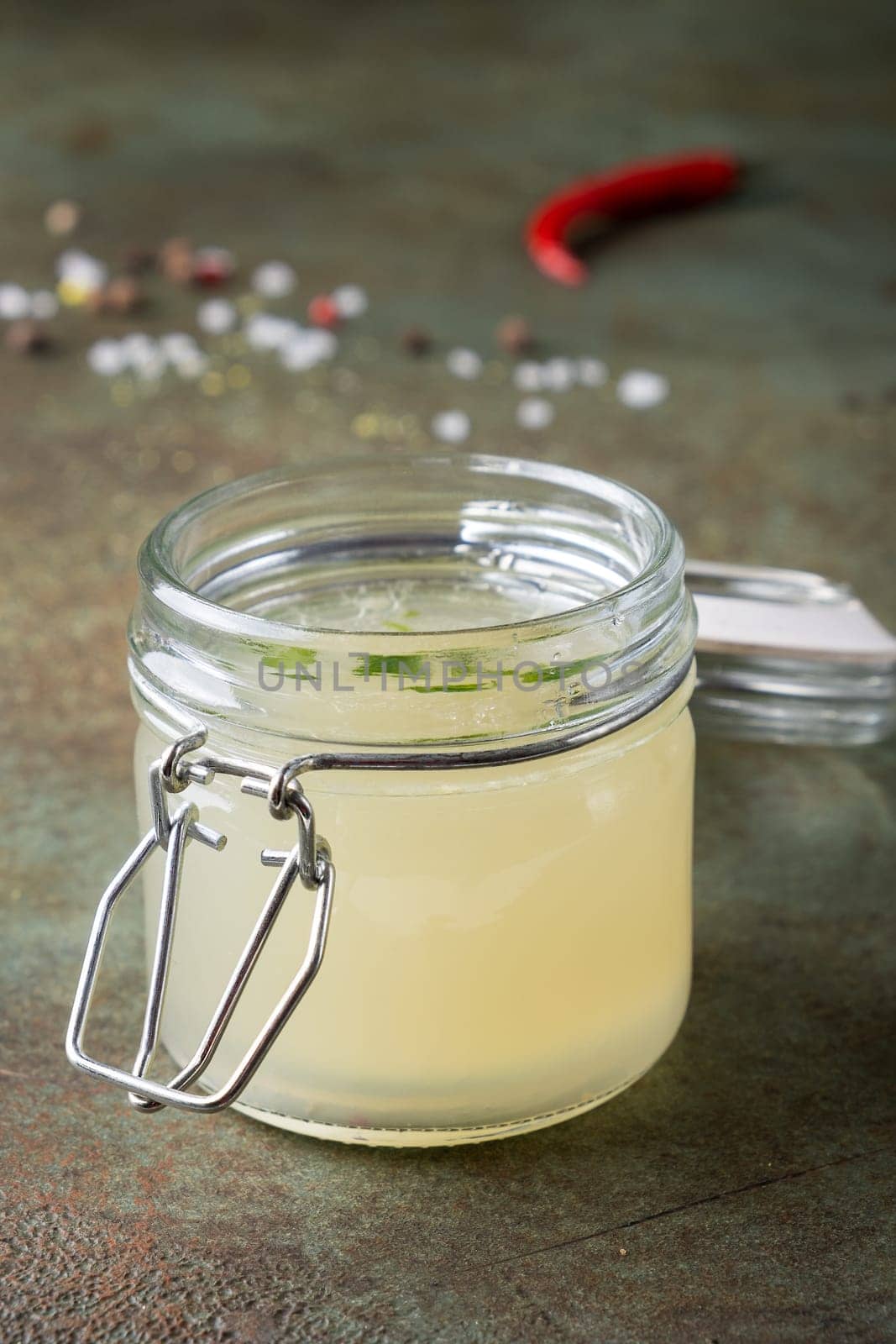 Close up meat broth in an open glass jar. Selective focus. Vertical orientation.