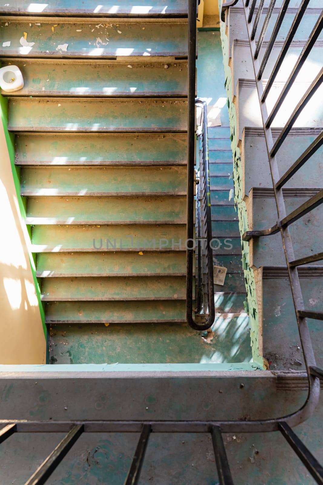 Top view of an old rectangular spiral staircase in an old abandoned building by Wierzchu