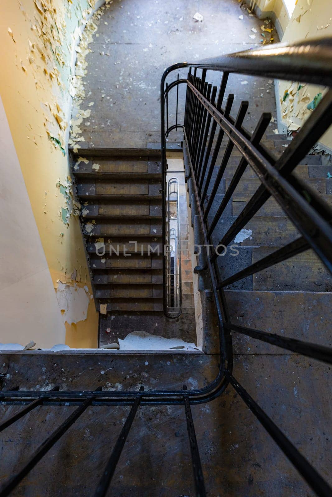 Top view of an old rectangular spiral staircase in an old abandoned building by Wierzchu