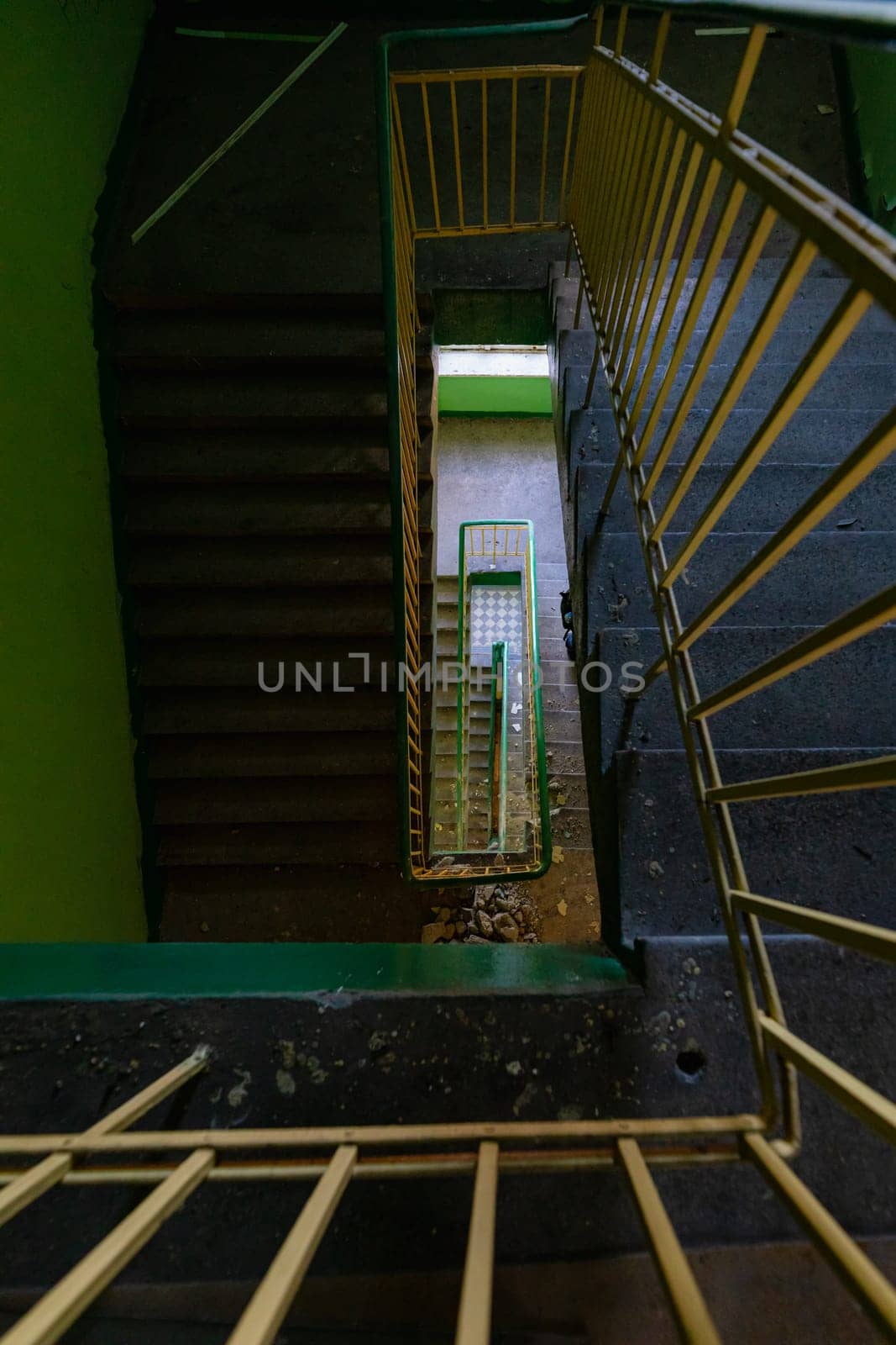 Top view of an old rectangular spiral staircase in an old abandoned building by Wierzchu