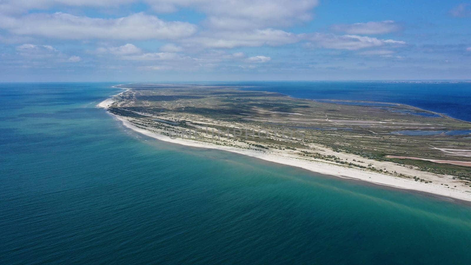 Aerial drone top down photo of seascape of island with sandy beach, turquoise clear waters of black sea in Ukraine and trees on island Dzharilgach