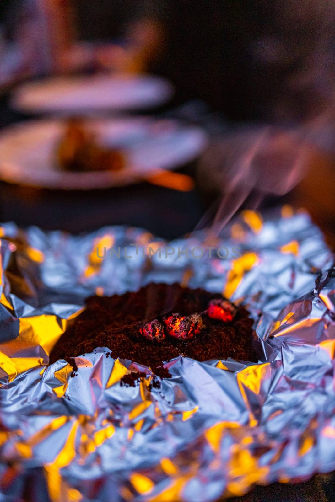 Tiny burning charcoal on pile of ground coffee as homemade mosquito repeller by Wierzchu