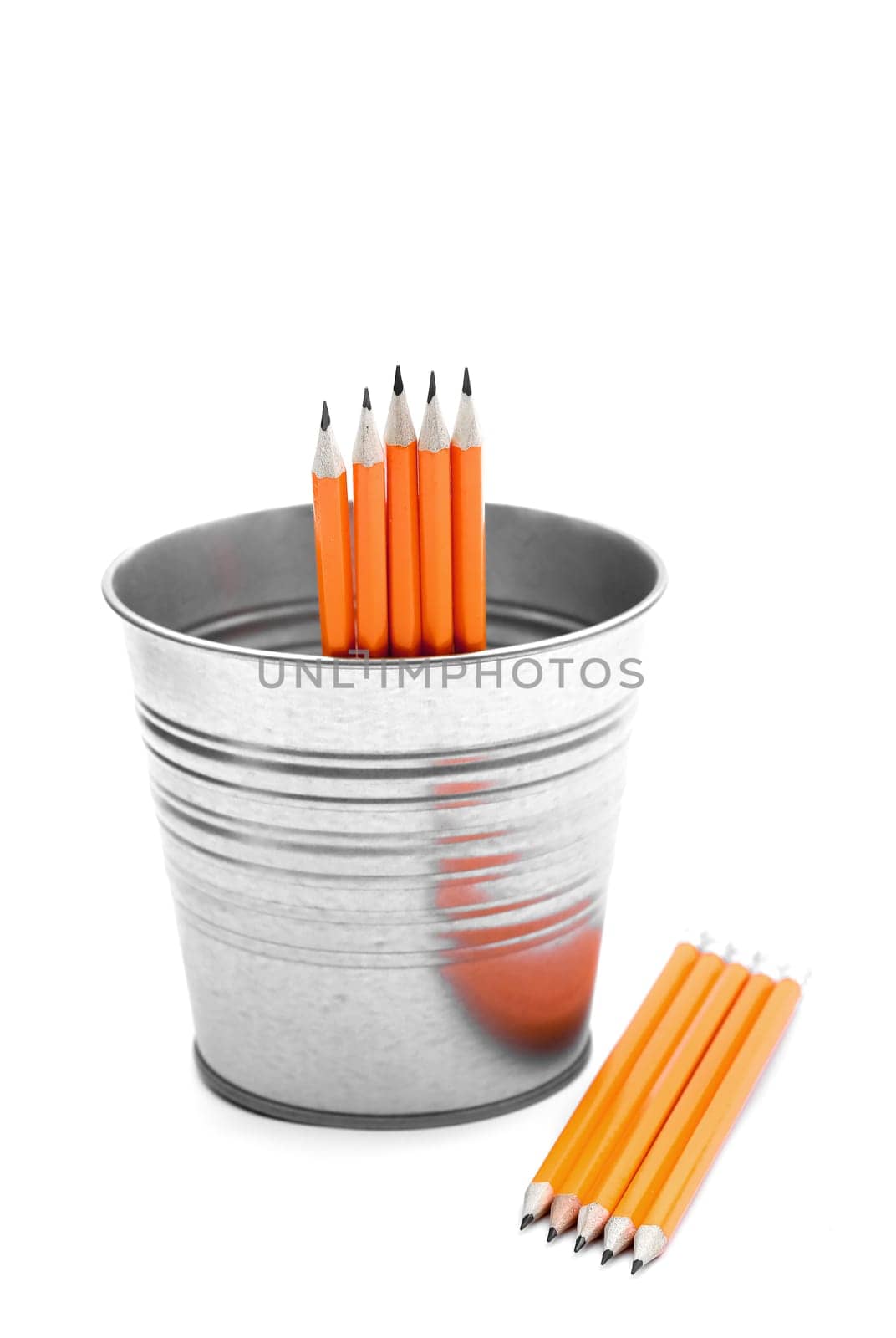 Isolated orange pencils on a clean white background in a metal bucket