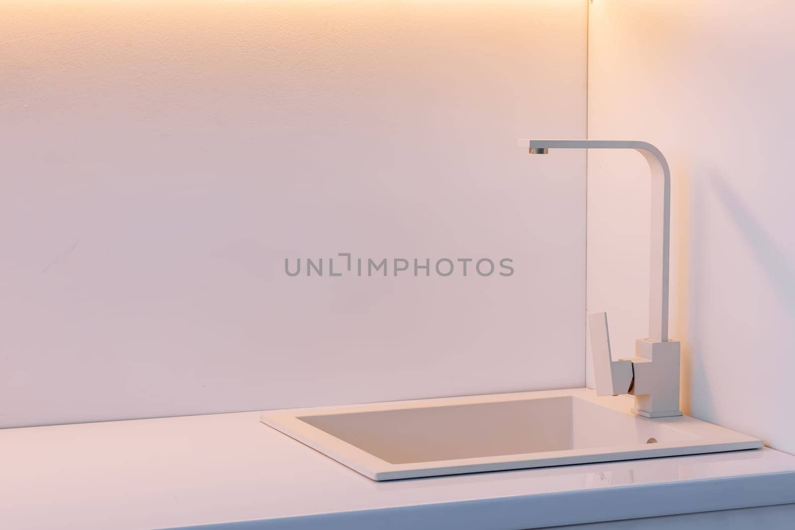 Modern kitchen with white countertop and white sink. High quality photo.