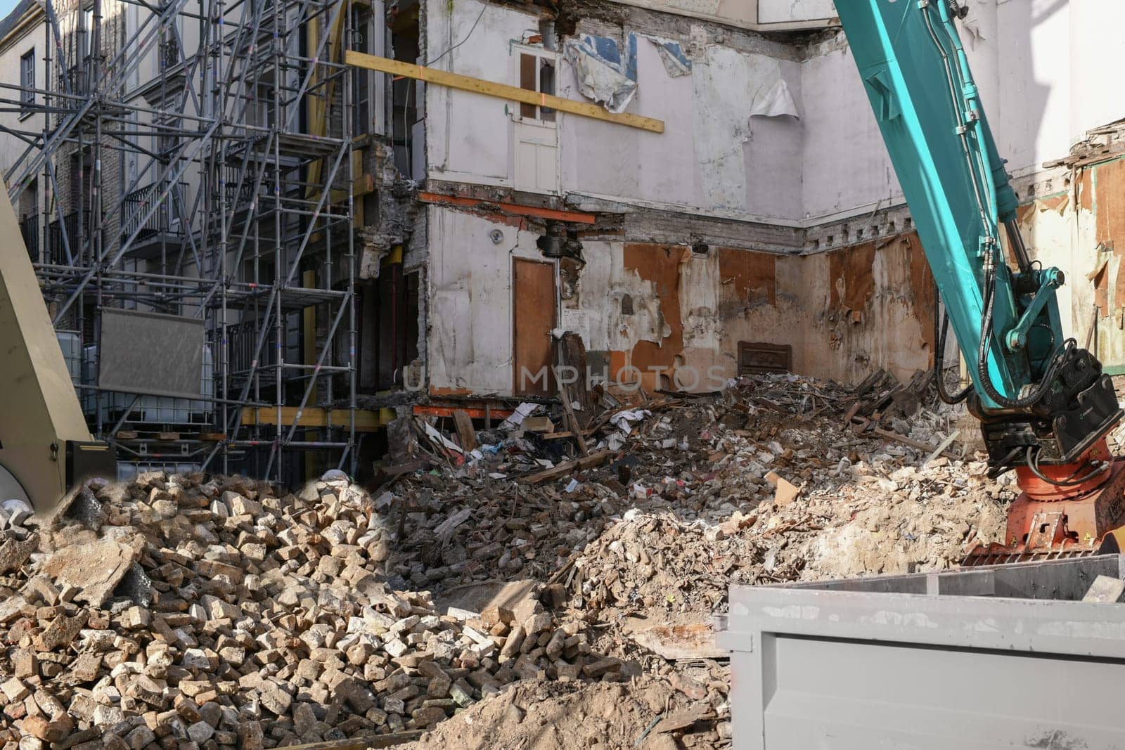 Ruined house. An excavator destroys a house with a bucket.