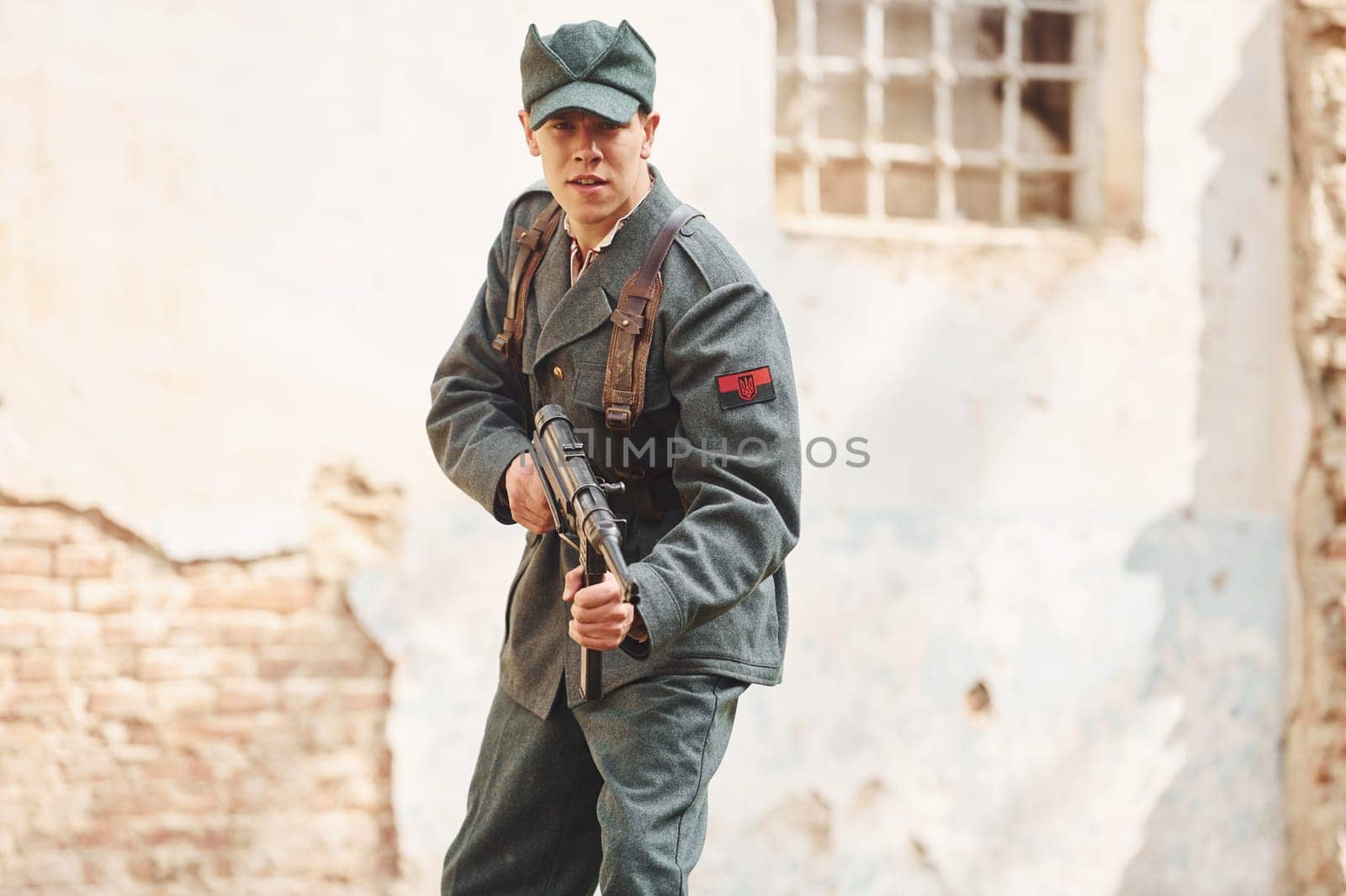 TERNOPIL, UKRAINE - June 2020 UPA Ukrainian Insurgent Army movie filming. Pictures of backstage. Young soldier with weapon near old building.